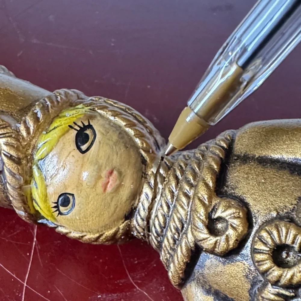 vintage chalkware candle holder featuring a metallic gold-finished figure